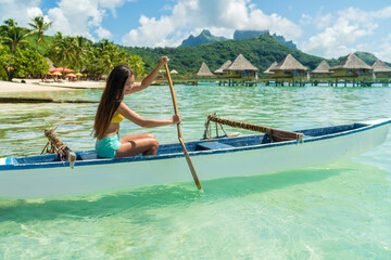 French Polynesia Tahiti travel vacation concept. Outrigger Canoe polynesian watersport sport woman...