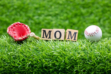 Baseball with word Mom for Mother's Day are on green grass