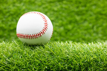 Baseball is on green grass background