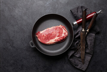 Raw beef ribeye steak on frying pan