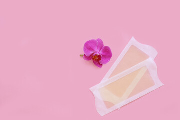 Depilatory product, wax strips on a pink background.