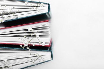 Books with fresh flowers on white background
