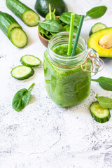 Green smoothie recipe. Healthy diet and nutrition, vegan and alkaline drinks. Fresh smoothie with cucumber, avocado and spinach on a gray stone. Copy space.