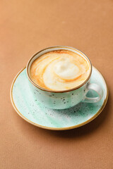 Cup of hot cappuccino coffee on color background