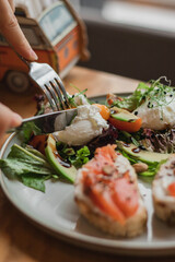 healthy breakfast, lunch or brunch of egg with avocado, fish and herbs