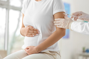Doctor vaccinating pregnant woman in clinic