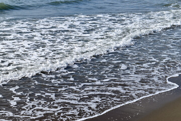 Sea waves crushing on shore. White sea foam. View from above.