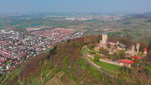 Beautiful top view of the Starkenburg castle in the German city of Heppenheim. The castle is high on the mountain. Mountains and the blue sky in the background. Tiled roofs of houses.