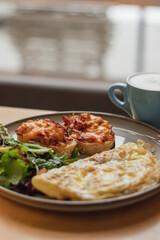 healthy breakfast, lunch or brunch of omelet with avocado, sandwiches and herbs and coffee