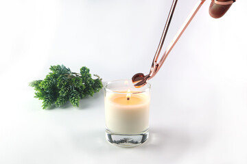 nice scented candle on the white table is cut the wick by rose gold wick trimmer for better burning...
