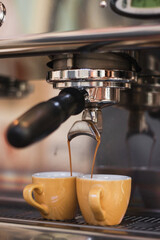 металлическая кофеварка пускает струи кофе в кружки в кафе на завтрак, обед или ланч