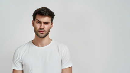 Young bearded man wearing t-shirt raising eyebrow