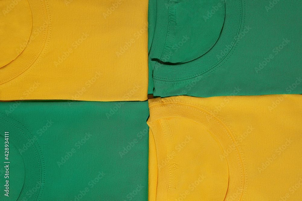 Sticker Closeup of four folded colorful yellow and green cotton t shirts. Flat lay tees template