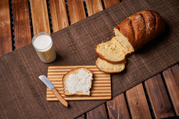 Fototapeta na wymiar Bread and chesse spread with glass of milk on wooden table