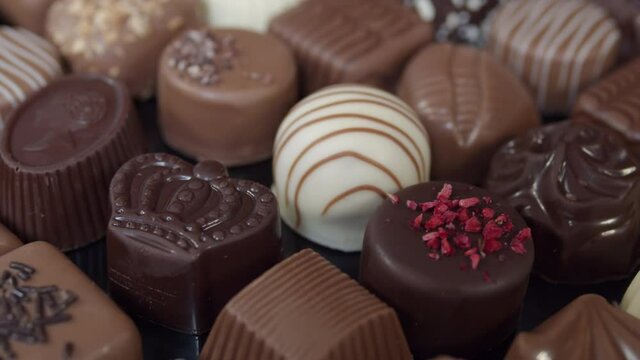 Close-up of bonbon chocolates pralines, camera moving through decorative sweets, valentines holiday gift.
