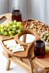 Serving wooden table for wine, glasses and snacks. Handmade segmented Portion wooden table. Grapes, cheese, wine and nuts.  