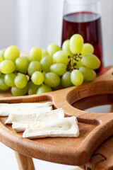 Serving wooden table for wine, glasses and snacks. Handmade segmented Portion wooden table. Grapes, cheese, wine and nuts.  