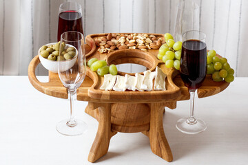 Serving wooden table for wine, glasses and snacks. Handmade segmented Portion wooden table. Grapes, cheese, wine and nuts.  