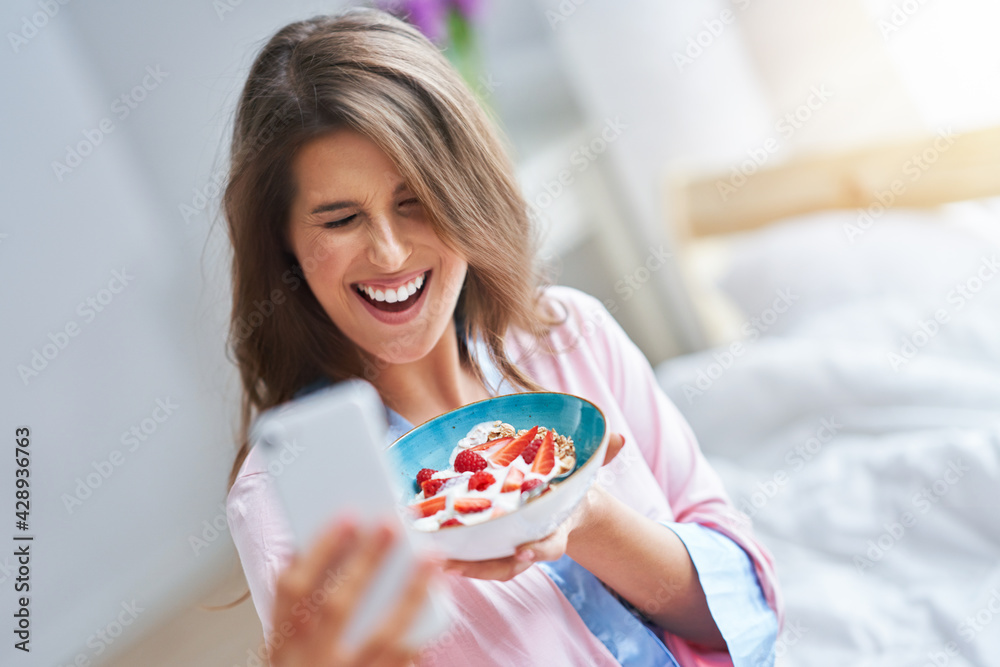 Wall mural young woman in underwear eating cereals