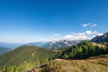 Fototapeta na wymiar Summer Landscape in Julian Alps seen from the Monte Santo di Lussari, Val Canale Valley, Tarvisio, Friuli Venezia Giulia, Italy. On the horizon the Peak of the Mount Mangart and Austria.