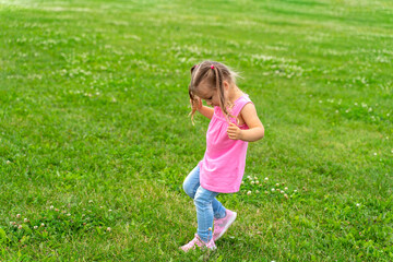 4 year old Caucasian girl running on the grass in sneakers