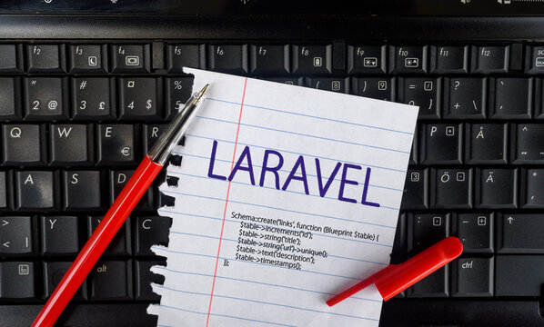 Laravel PHP Framework programming language. Word Laravel on paper and laptop