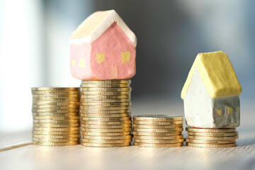 The lovely ceramic house on the coins use as saving money for house and success in financial concept