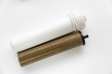 Dirty filter cartridge drinking water on a white background. Replacing cartridges is a mandatory procedure that must be carried out to maintain quality water purification. Pollution.