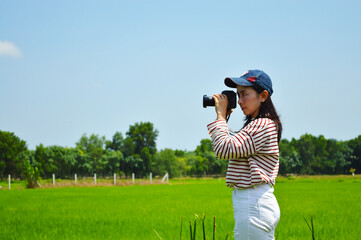 Women in striped shirts with white pants Using camera