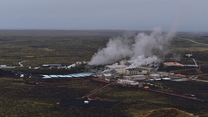 Fototapeta na wymiar Stunning aerial view of Svartsengi geothermal power plant with pipelines for hot water and steaming stacks near Grindavik, Reykjanes peninsula, Iceland in winter season viewed from Þorbjörn mountain.