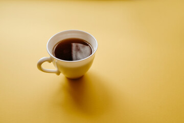 a cup of tea on a yellow background