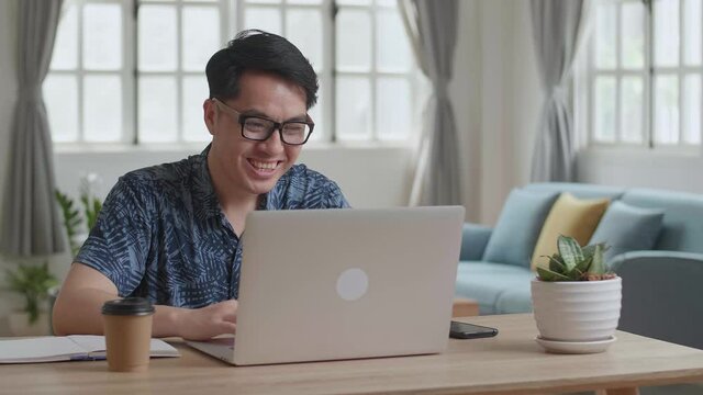Man Working On Laptop Computer And Celebrating At Desk