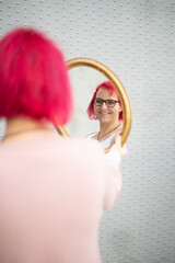 Frau mit pinken Haaren betrachtet sich im Spiegel &ndash; Selbstbild und Individualit&auml;t