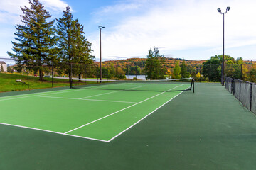 Empty tennis court in the park on sunny day - obrazy, fototapety, plakaty