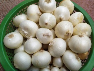 white onions In green coloured plactic bowl