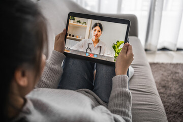Fototapeta na wymiar patient women video conference remote on a tablet with a doctor for consultation the treatment of disease at home, work from home and social distancing concept.