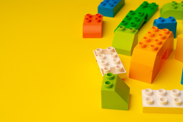Obraz premium Kids toy constructor details scattered on yellow background