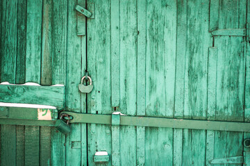 rusty lock on a texture of old, wooden, Green tide, celadon door. the passage is closed. locked. place for text.