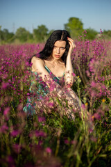 Fototapeta na wymiar Girl in a turquoise dress in a blooming field
