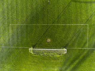 Aerial view on a green grass football or soccer field . Long shadows on the ground. Nobody. Training pitch. Day time © mark_gusev