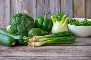 Green healthy vegetables on wooden background