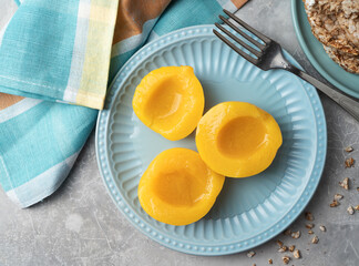 Sliced canned yellow peach with syrup on a blue plate