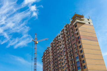 Fototapeta na wymiar Tall skyscraper under construction with crane. Construction industry.