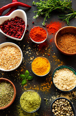 Colorful and aromatic herbs and spices on a dark background