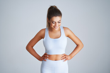 Adult beautiful woman working out over light background