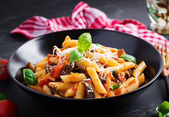 Pasta penne with eggplant. Pasta alla norma - traditional Italian food with eggplant, tomato, ricotta cheese and basil.