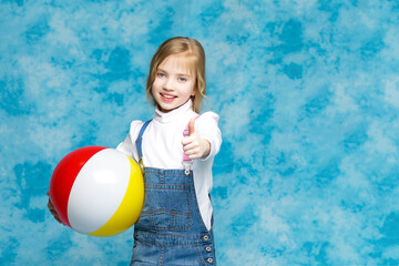 Little girl is playing with a ball.The concept of children's sports, summer outdoor recreation.