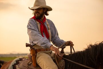 cowboy on horseback against a beautiful sunset, cowboy and horse at first light,mountain, river and...