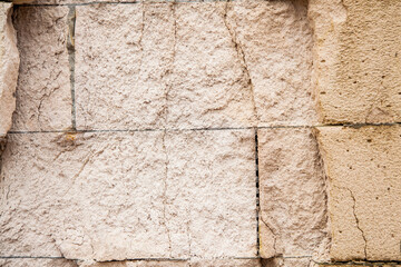Cracks on the white wall blocks. The destruction of the wall. Background texture