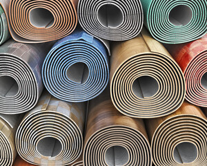 Front view on linoleum rolls with different color, texture, pattern stacked one on another, 3d...